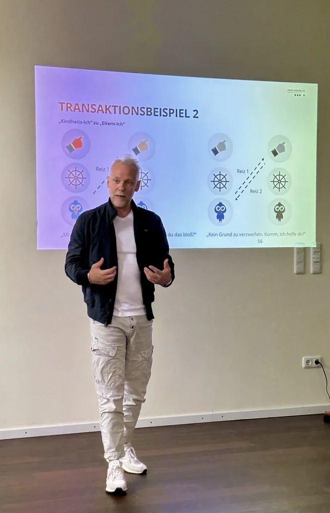 Trainer erläutert ein Transaktionsbeispiel im Führungskräftetraining bei HLP Consulting